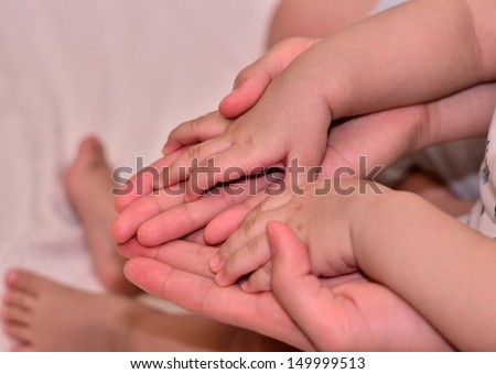 Baby\'s small hand on mommy\'s big hand