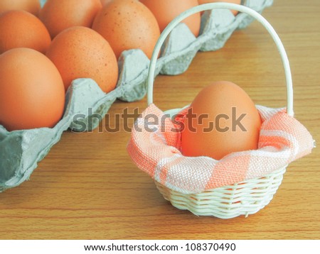 Fresh brown chosen egg in mini basket, separated from others egg. Like a child born from higher class of society, well treated and raised.