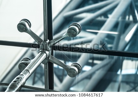 Architecture abstract background. Glass curtain walls. Metal fasteners elements of spider glass system. Facade detail Windows