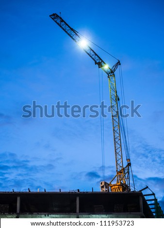 Light from crane operating on the building before the night time