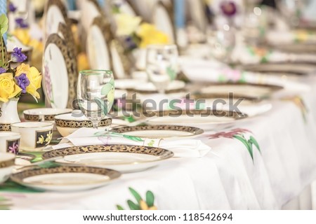 Porcelain set of plates, dishes, utensils, and water glasses. selective focus on transparent glass