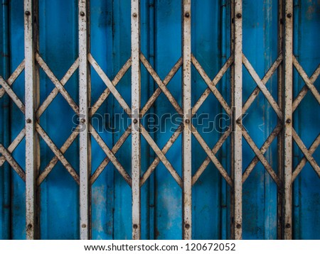 Old rusty metal blue door in suburb of Thailand can be used as vintage background