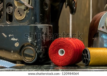 Red Thread for sewing and part of sewing machine, still life art photography