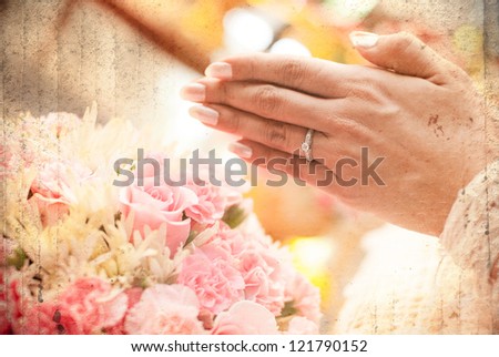 Thai wedding hand of a bride receiving holy water from elders with wedding ring on her finger and flower on the left. photo layered with old graphic