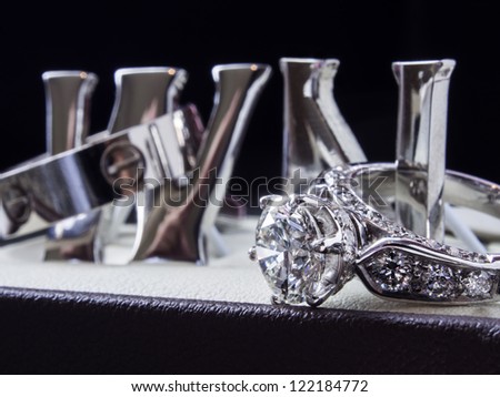 Huge wedding diamond ring on shiny N and W silver letter on the black background