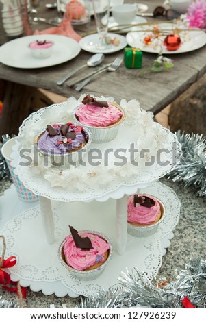 Cupcake with many decorative vintage stuffs. with wooden table in the background set up for party or wedding