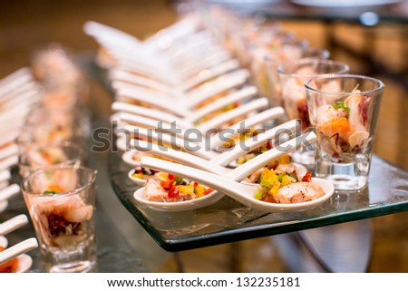 Cocktail party with variety of desserts and food decorated in spoons arranged in orderly fashion
