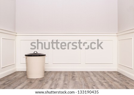 Trash can in the corner of vintage room with wood like rubber floor, laminate floor