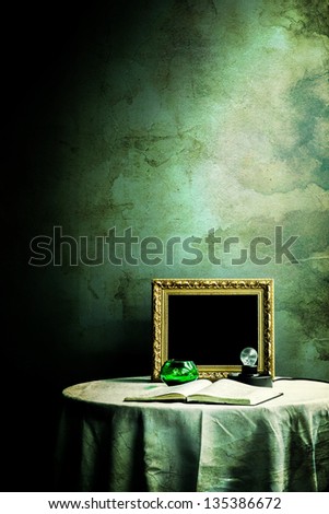 Grunge photo frame on table with light bulb and book added with grunge layer paper and dark shadow