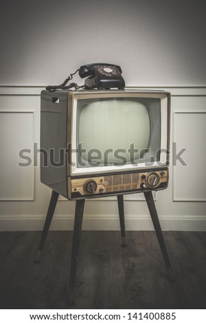 Old Television With 4 Legs In The Corner Of Vintage Room And A Black Old Telephone On It, Edited With Vintage Old Style With Vignette