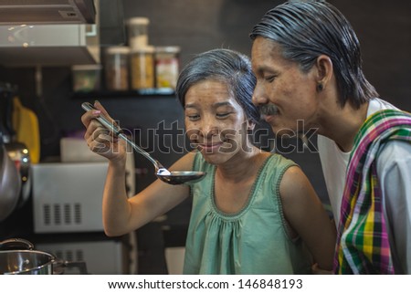 Thai couple make up as old people in their house doing their daily routine