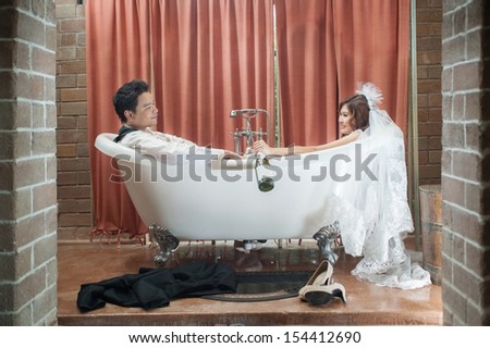 Asian couple in bath tub chilling with each other with alcohol drink