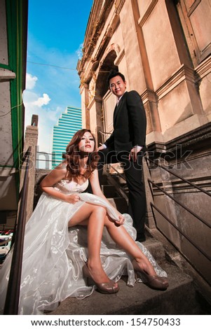 asian newly wedding couple posing for pre wedding photography with vintage old wall surrounding