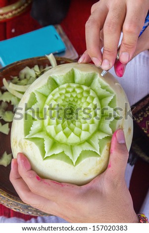 Thai fruit art with hand of teacher carving on process