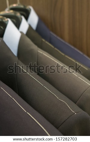 shoulder of suits hanging with thread sewed on them