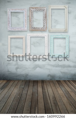 vintage wooden frames on wall with wooden floor