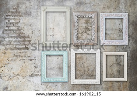 vintage old wooden frames on concrete grungy wall