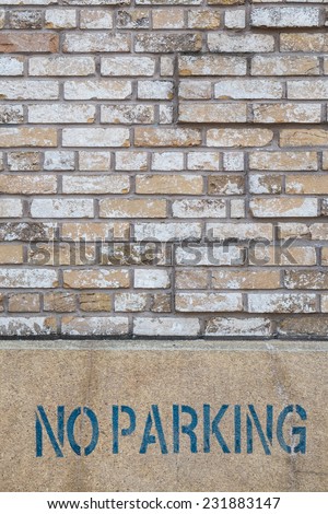 no parking sign on brick wall