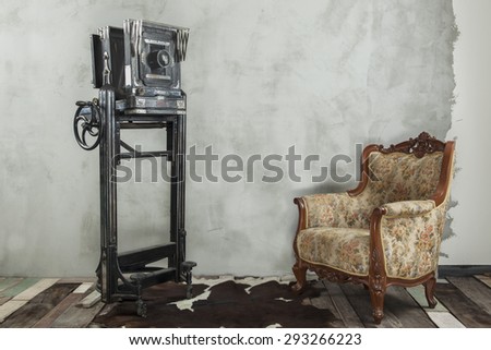 Vintage decoration, old camera and sofa on wooden floor and undone cement wall
