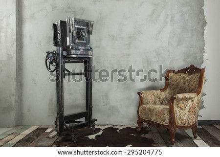 Vintage decoration, old camera and sofa on wooden floor and undone cement wall