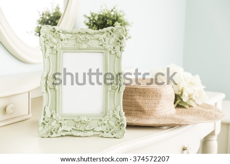 High key photo of Vintage frame on table with hat in front of the mirror, bedroom scene