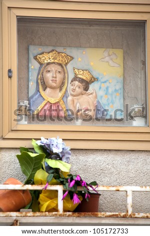 niche in the wall with Virgin Mary and Christ child image tile, candle and flowers, Sicily, Italy