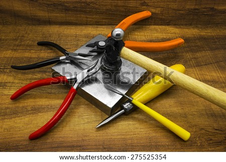 Jewelry making tools on a wooden background.