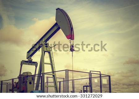 oil rig pumping on cloudy sky background