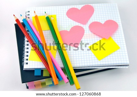 heart and pencils on checked school paper of notepad