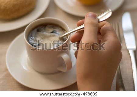 man\'s hand stirring coffee