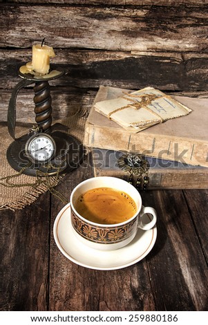 Coffee, old books and candle in a still life in vintage style