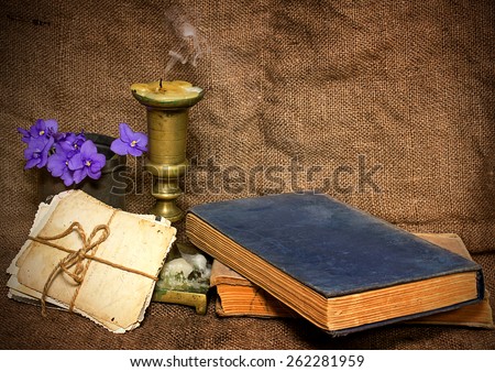 Old photographs, candle extinguished, flowers spring in the composition in a rustic style