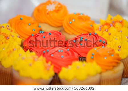 Creamy colored cupcakes with blue and pink sprinkles