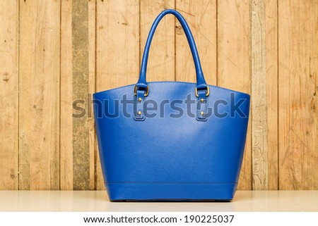 blue purse on wood background, luxury women accessory