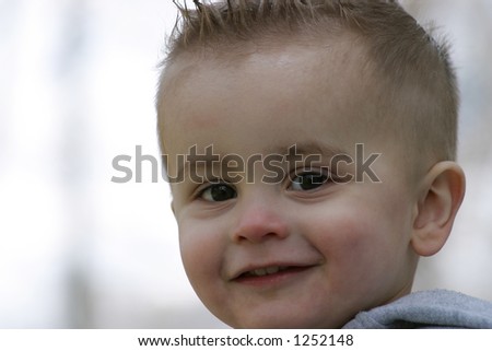 a boy smiling to the right side of the frame