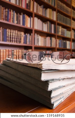Glasses and books on library table