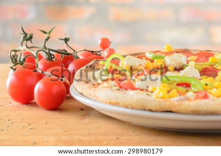 Pizza with pepper, tomato, corn and feta