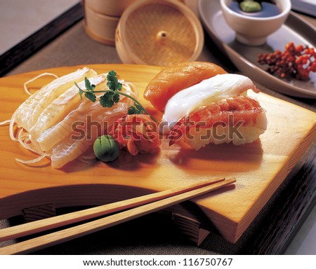 High angle view of sashimi and sushi rolls on a serving board