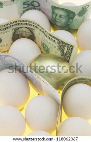 bills from different countries standing among white eggs with golden egg in middle