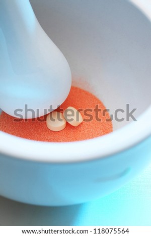 Orange powder and two white tablets in bowl