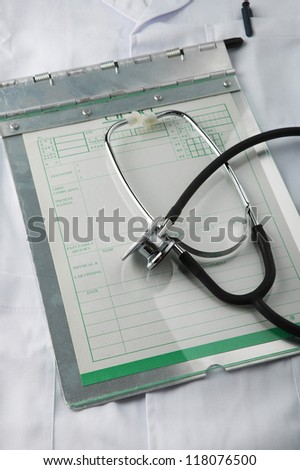 A doctor chart and a stethoscope on a doctor gown