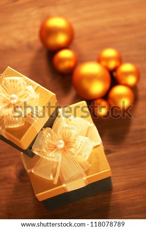 High angled of two golden boxes and the Christmas tree decorations on the wood table