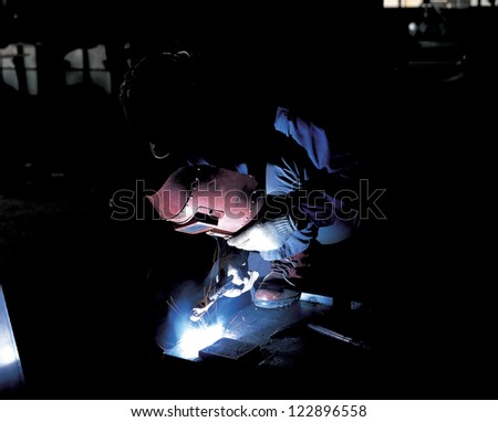 Worker welding in protective helmet
