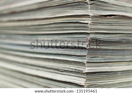 Full frame close up shot of a corner of a stack of magazines.
