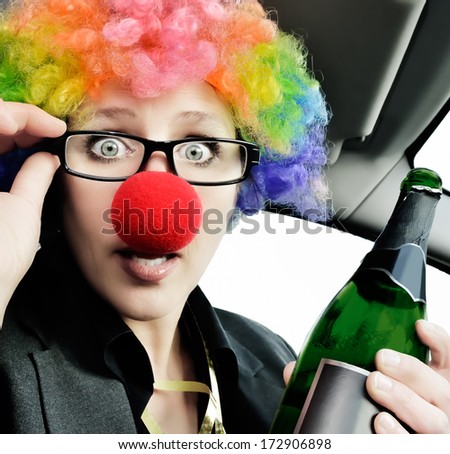 DonÂ?Â?t drink and drive.  Only choose drinks without any alcohol, when you want to drive. Attractive woman with clown nose and wig winking at the camera