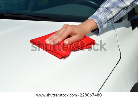 Car care - Car polishing - Polishing a white car with a red cloth.