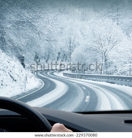 Winter Driving - Curvy Snowy Country Road - Curvy snowy country road leading through a mountain landscape.