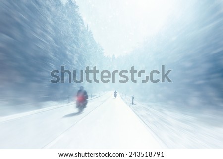 Winter Motorcycling - Motorbike drivers on a snowy winter day (motion blur)