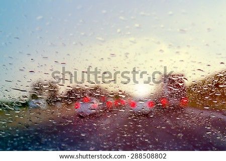 Bad Weather Driving - traffic jam on a highway - selective focus on raindrops on the windshield