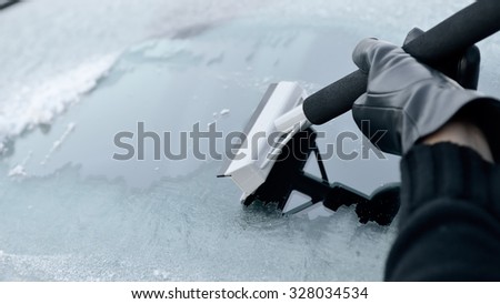 Winter Driving - Woman Scraping Ice from a Windshield